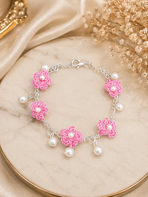 Close up of pink crochet floral charm bracelet with pearl drops